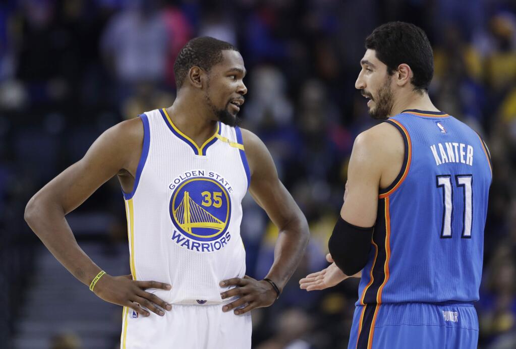 The Golden State Warriors' Kevin Durant, left, talks to Oklahoma City Thunder's Enes Kanter during the first half Wednesday, Jan. 18, 2017, in Oakland. (AP Photo/Marcio Jose Sanchez)