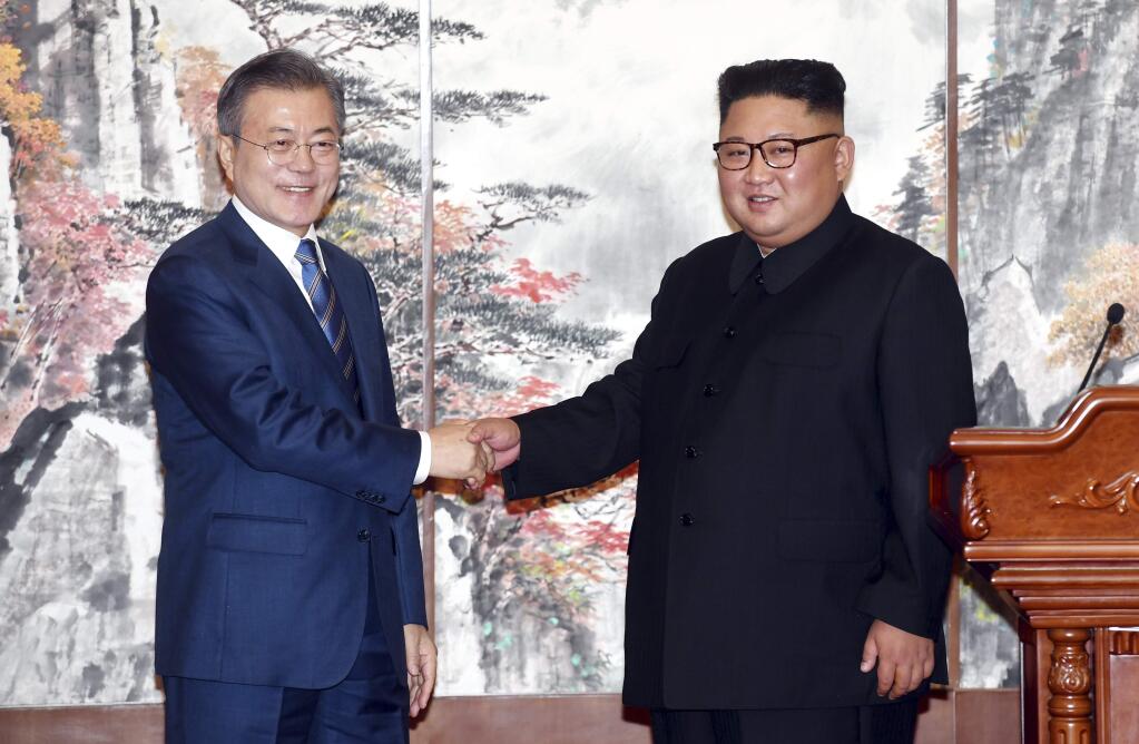 South Korean President Moon Jae-in, left, and North Korean leader Kim Jong Un shake hands after signing the documents in Pyongyang, North Korea, Wednesday, Sept. 19, 2018. Moon and Kim announced a sweeping set of agreements after their second day of talks in Pyongyang on Wednesday that included a promise by Kim to permanently dismantle the North's main nuclear complex if the United States takes corresponding measures, the acceptance of international inspectors to monitor the closing of a key missile test site and launch pad and a vow to work together to host the Summer Olympics in 2032.(Pyongyang Press Corps Pool via AP)
