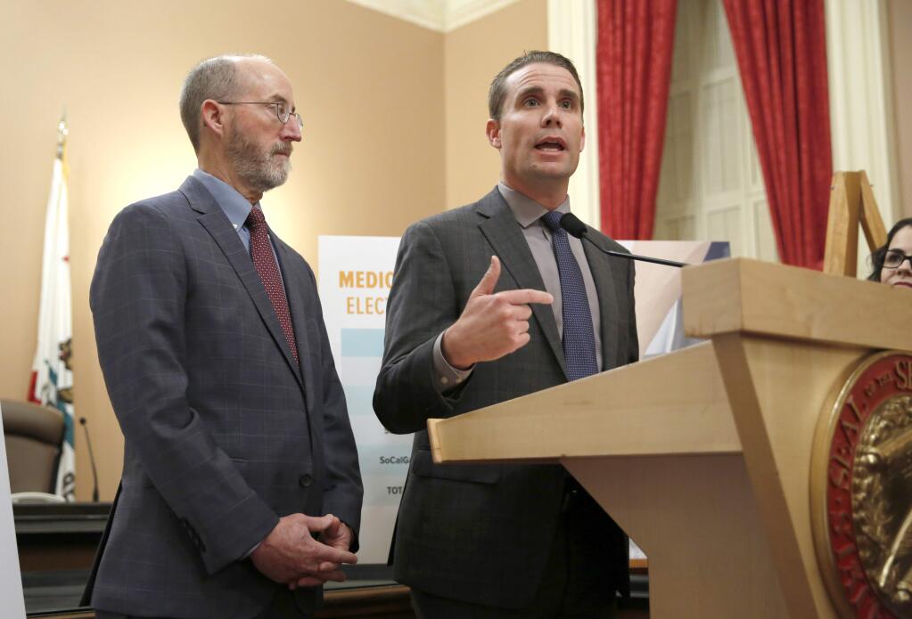 State Sen. Mike McGuire, D-Healdsburg, right, accompanied by Sen.Steve Glazer, D-Orinda, left, discusses a package of legislation they introduced that includes a proposal to require telecommunication companies to have at least 72 hours of back-up power cellphone towers in high-risk fire areas, during a news conference in Sacramento, Calif., Wednesday, Jan. 8, 2020.. (AP Photo/Rich Pedroncelli)