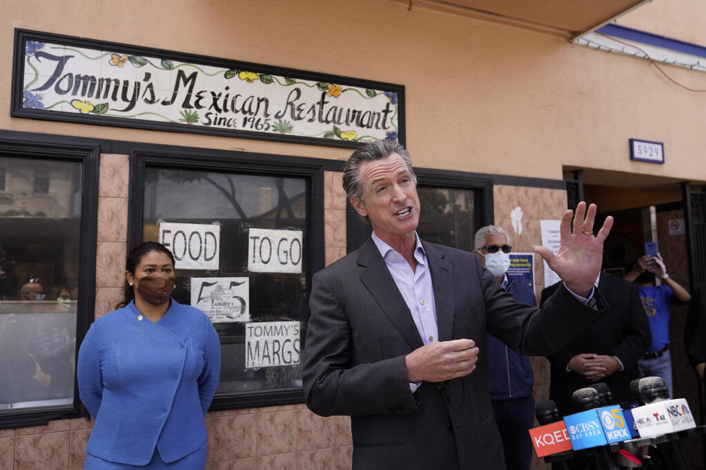 California Gov. Gavin Newsom speaks at a news conference about relief for restaurants as San Francisco Mayor London Breed looks on outside Tommy's Mexican Restaurant in San Francisco, on Thursday, June 3, 2021. The governor offered his support for the extension and expansion of outdoor dining and takeout cocktails. (AP Photo/Eric Risberg)