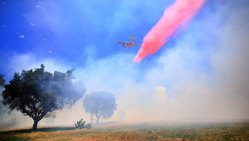 A Cal Fire air tanker drops fire retardant across the head of the west fire on Mark West Springs Road, Wednesday, May 26, 2021 near Larkfield. (Kent Porter / The Press Democrat) 2021