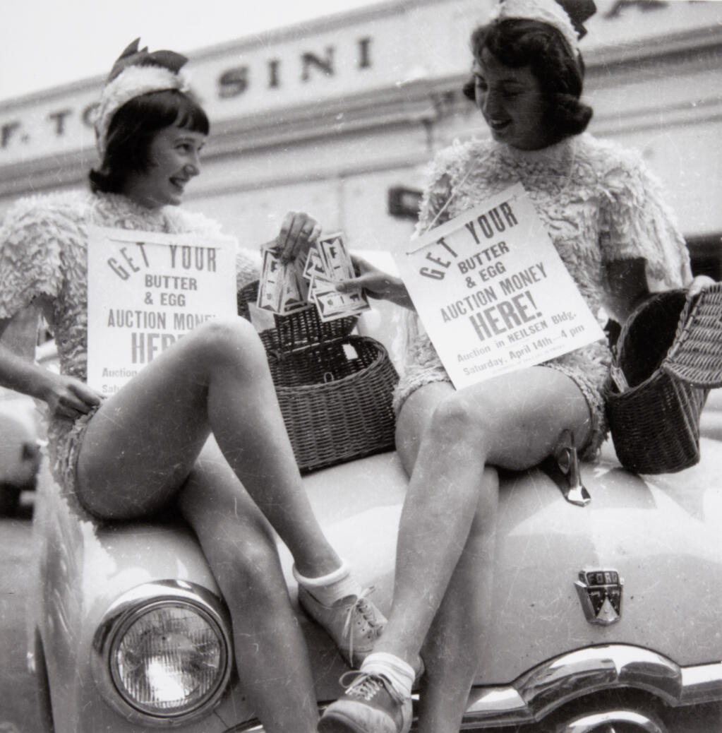 Two unidentified women dressed as chickens sit on the hood of a car in Petaluma in 1947 as the hold signs to promote a Butter & Egg event. (Sonoma County Library)
