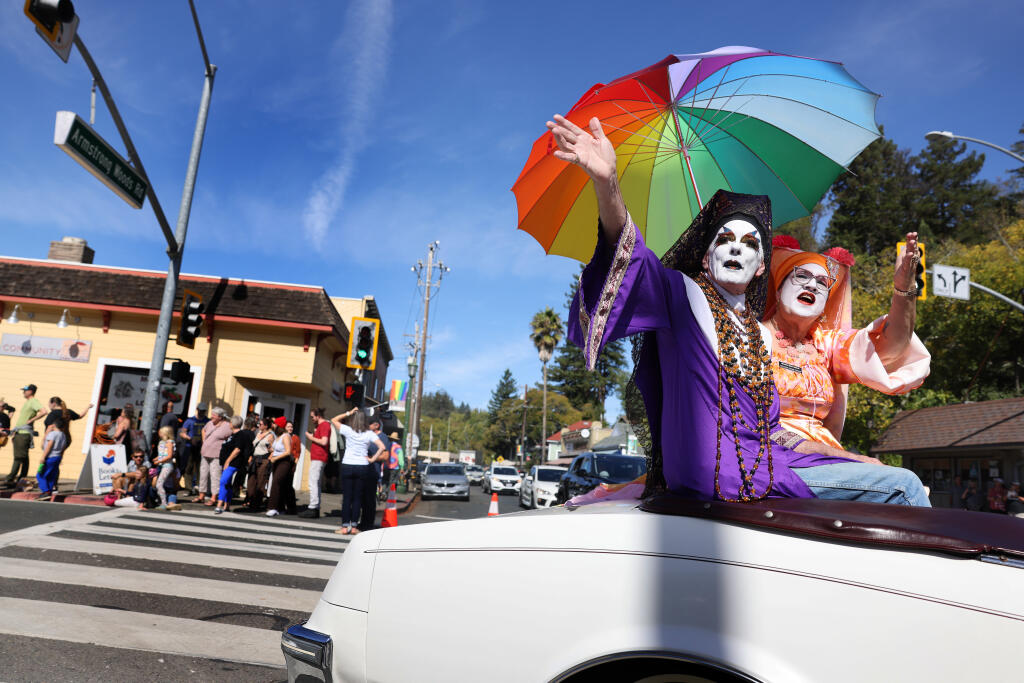 Sister Sparkle Plenty, left, and Sister Sara Femme Fatale, members of the Russian River Sisters of Perpetual Indulgence, wave to the crowd during the Sonoma County Pride Parade  in Guerneville, Sunday, Oct. 15, 2023. (Beth Schlanker / The Press Democrat)