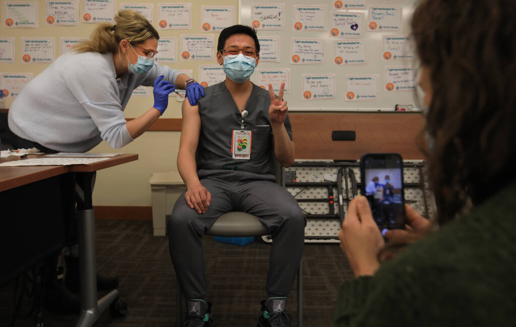 Sutter doctor Jimmy Le is photographed by fellow doctor Hannah Kazak as they receive their second round of the Pfizer-BioNTech COVID-19 vaccine at Sutter Santa Rosa Regional Hospital, Friday, Jan. 8, 2021. (Kent Porter / The Press Democrat) 2021