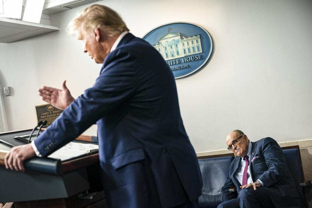 Rudy Giuliani, then former President Donald Trump's personal lawyer, listens as Trump speaks during a news conference at the White House in Washington on Sept. 27, 2020. An associate of Giuliani tried to pass a message to Trump asking him to grant Giuliani a “general pardon” and the Presidential Medal of Freedom just after the Jan. 6 attack on the Capitol, according to a new book. (Al Drago/The New York Times)