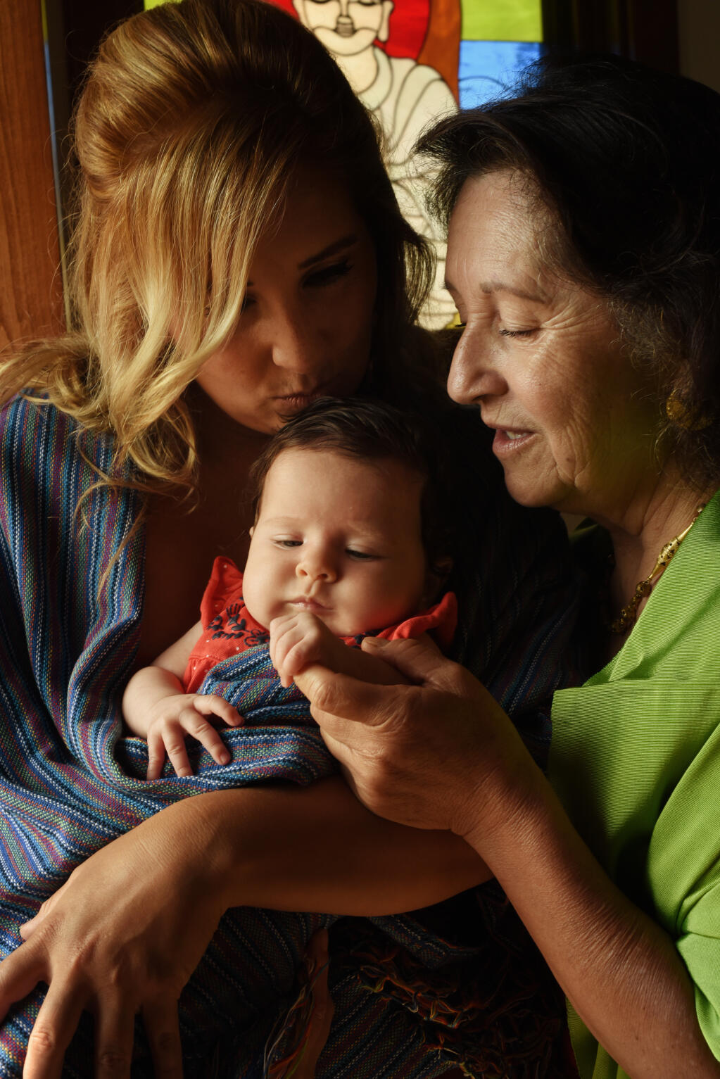 Amelia Morán Ceja with her daughter, Dahlia Ceja Swedelson, and her 10-week-old granddaughter, Luna Isabella Ceja Swedelson, at La Capilla; a chapel that sits near Amelia’s home in Napa. Amelia said mothers show love through food. She cooks with her daughter just as her grandmother cooked with her in Mexico. (Erik Castro/For The Press Democrat)