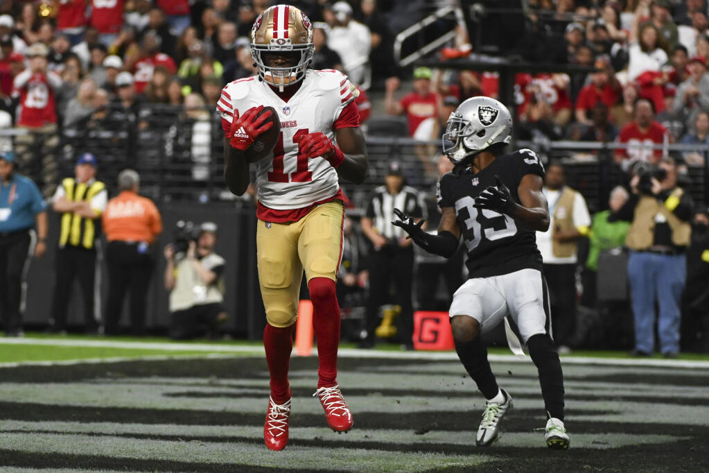San Francisco 49ers wide receiver Brandon Aiyuk scores on a touchdown pass during the first half of an NFL football game between the San Francisco 49ers and Las Vegas Raiders, Sunday, Jan. 1, 2023, in Las Vegas. (AP Photo/David Becker)
