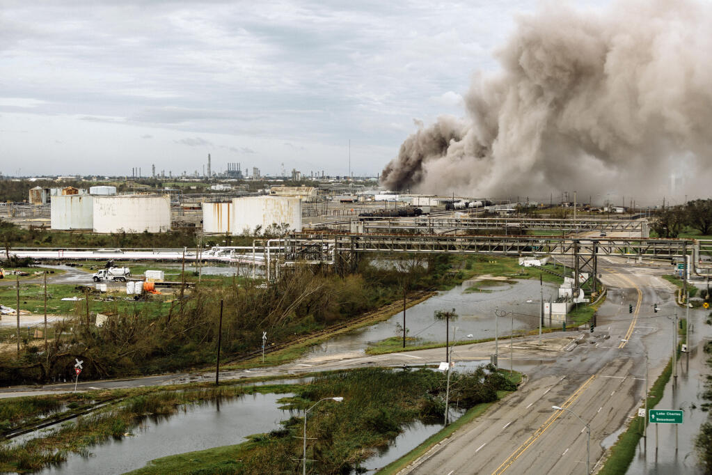 FILE — A fire burns at an industrial site in the aftermath of Hurricane Laura in Lake Charles, La., Aug. 27, 2020. A growing body of research shows that the Federal Emergency Management Agency, the government agency responsible for helping Americans recover from disasters, often helps white disaster victims more than people of color, even when the amount of damage is the same. (William Widmer/The New York Times)