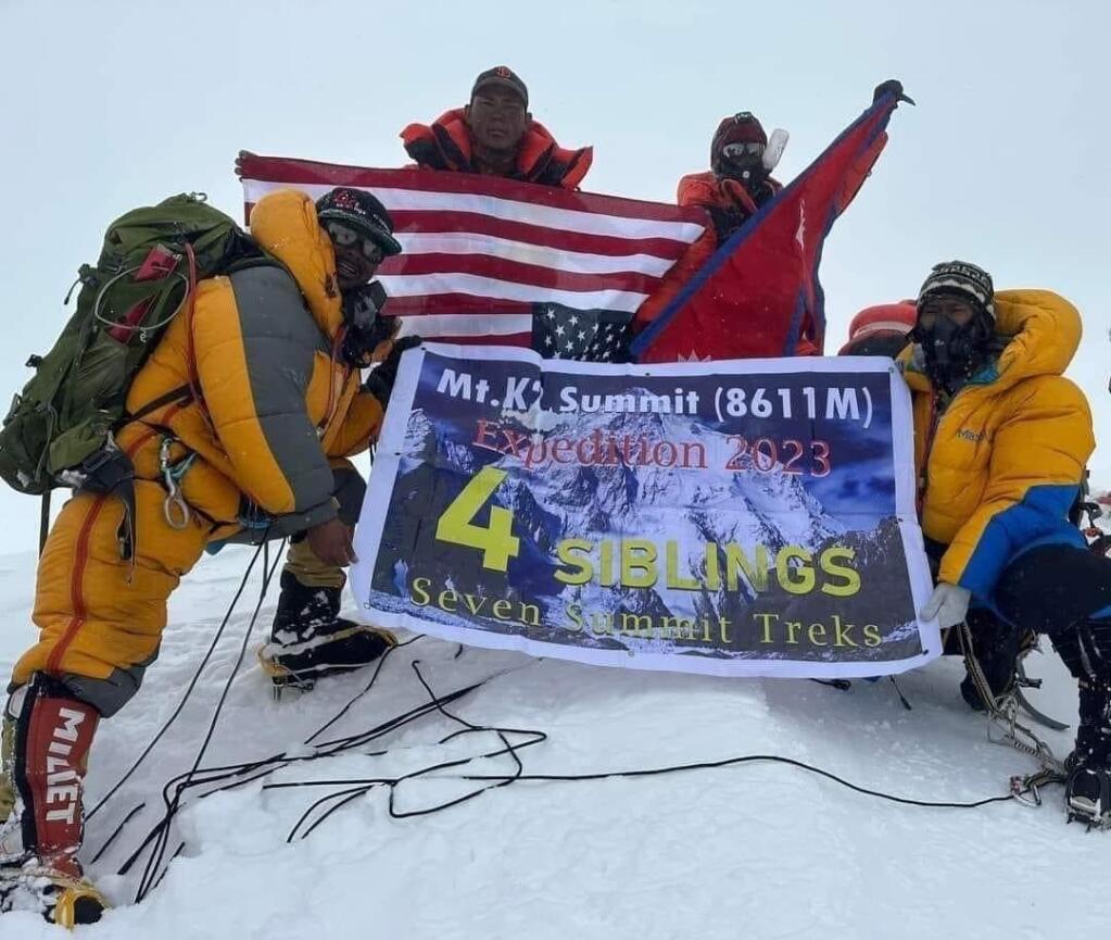 From left, Nigma Dorchi Sherpa, Ang D Sherpa, Pechhumbe Sherpa and Muktu Sherpa holding their expedition flag at the summit of K2 on July 27, 2023. (Submitted)