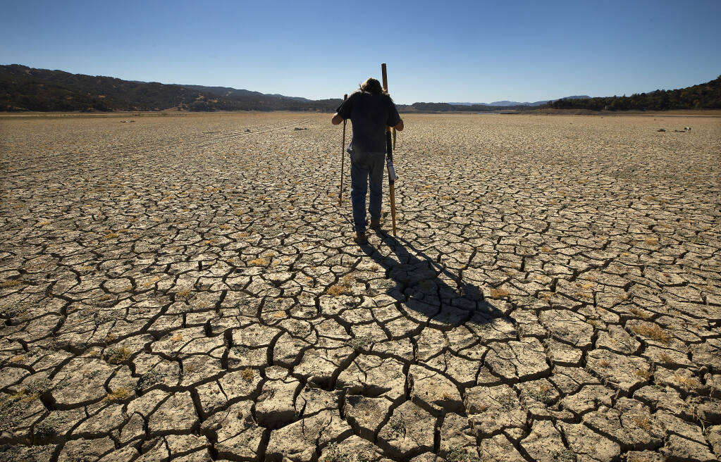 Andy Mattern walks to the middle of a dried out Lake Mendocino. (JOHN BURGESS / The Press Democrat)