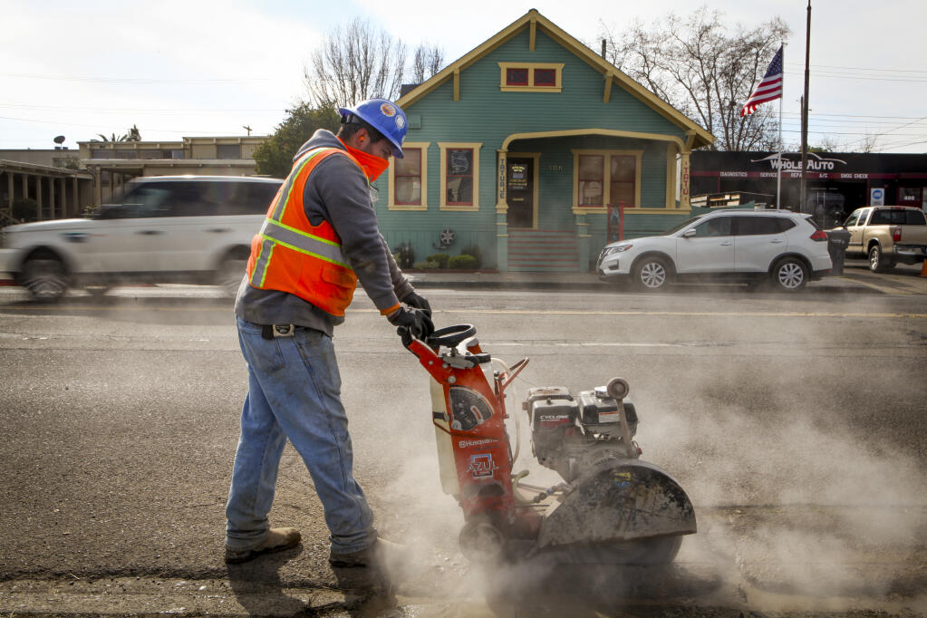 A worker carves into Petaluma Boulevard South as cars pass by ferrying residents on their morning commutes Tuesday, Jan. 18, 2022. Long await road work began this week on Petaluma Boulevard South, which funnels traffic from downtown to the city’s southernmost Highway 101 access point. (CRISSY PASCUAL/ARGUS-COURIER STAFF)