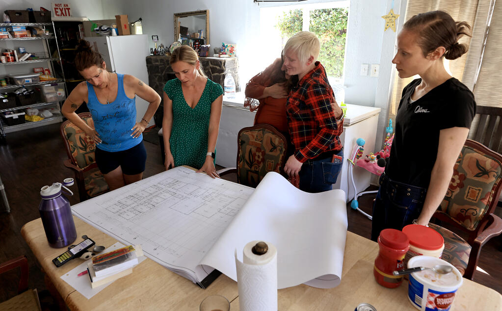 Molly Gallaher Flater, in green, unveils plans for the new Hope Village, Tuesday, Sept. 6, 2022 to, from left, resident Rachelle Chatham, Erika Klohe, the Buckelew Program's regional director embracing a tearful resident Danielle Jones in plaid and Kelsey Wambold. (Kent Porter / The Press Democrat)