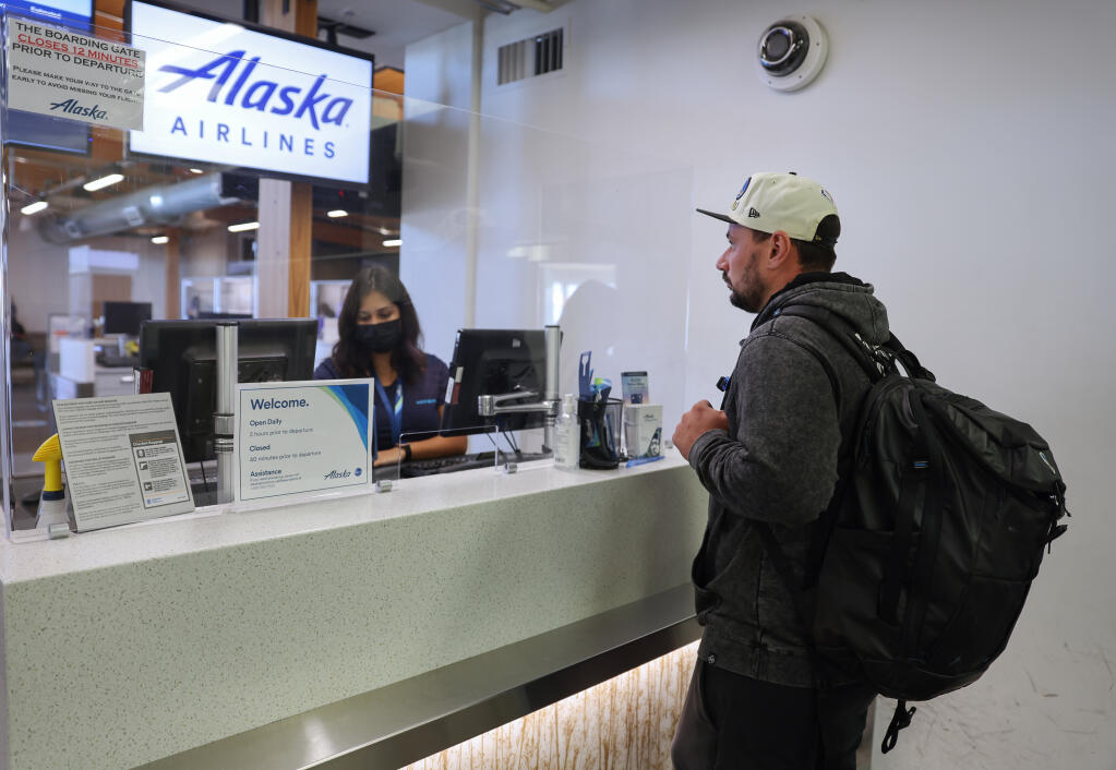 Thomas Trumper checks in for his flight at the Alaska Airlines ticket counter in the Charles M. Schulz-Sonoma County Airport in Santa Rosa on Monday, September 26, 2022.  (Christopher Chung/The Press Democrat)
