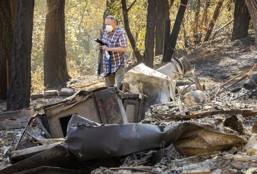 Jay Gamel, longtime publisher and editor of the Kenwood Press photographs the remains of a house he owned for nearly 50 years on Adobe Canyon Road when the Glass fire raged through the area near Sugarloaf State park.  (Photo by John Burgess/The Press Democrat)