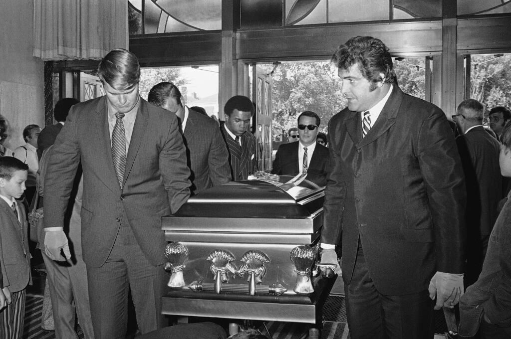 FILE  - In this June 19, 1970, file photo. Chicago Bears teammates of Brian Piccolo carry his coffin into Christ the King Church for funeral services in Chicago. From left, front to back, are Randy Jackson, Dick Butkus, and Gale Sayer. Ed O'Bradovich is at right. Hall of Famer Gale Sayers, who made his mark as one of the NFLâ€™s best all-purpose running backs and was later celebrated for his enduring friendship with a Chicago Bears teammate with cancer, has died. He was 77. Nicknamed The Kansas Comet and considered among the best open-field runners the game has ever seen, Sayers Sept. 23, 2020, according to the Pro Football Hall of Fame. (AP Photo/File)