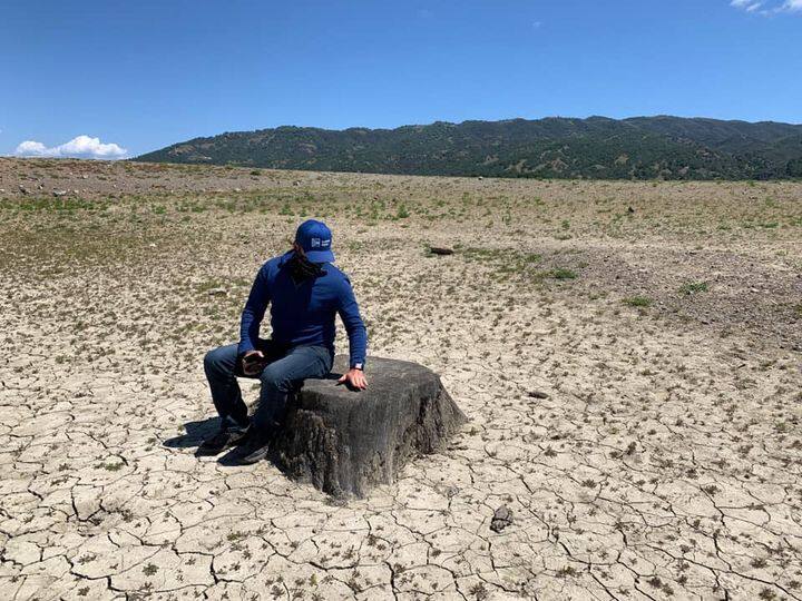 Sonoma Water’s Brad Sherwood sits on a stump in a parched Lake Mendocino. Photo courtesty Brad Sherwood.