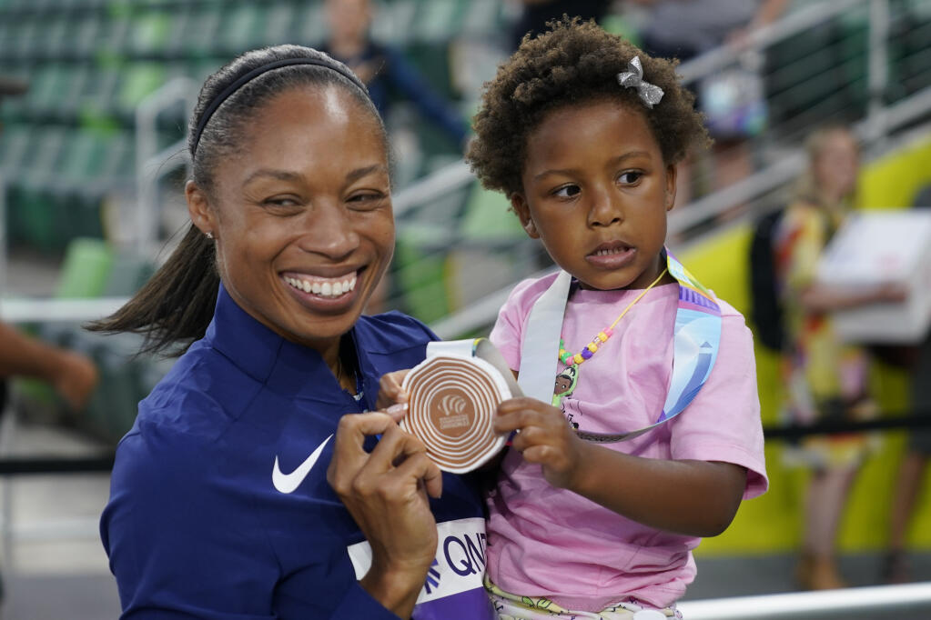 Allyson Felix of the United States gives her daughter Camryn her bronze medal after the 4x400-meter mixed relay final at the World Athletics Championships last month in Eugene, Oregon. (Charlie Riedel / ASSOCIATED PRESS)