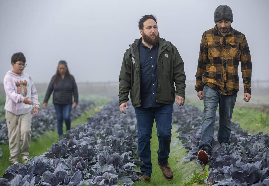 Andy Naja-Riese, left, the CEO of AIM (Agricultural Institute of Marin), which assists the farming community as an advocate and runs farmers markets, walks with Ortiz Farms owner Eric Ortiz, while visiting the Sebastopol farm Monday December 4, 2023. Naja-Riese said more emphasis needs to be placed on supporting small family farms, not the large-scale industrial ag complexes, in the delayed farm bill. (Chad Surmick / The Press Democrat)