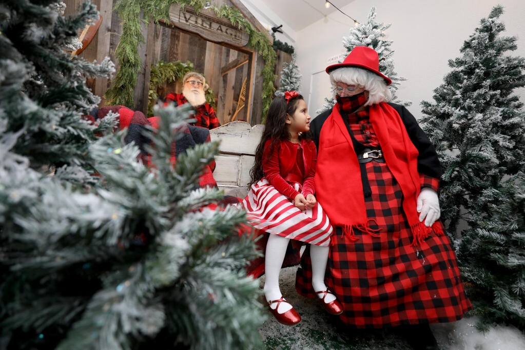By special request, Sofia Moreno-Franco, 4, visits with Mrs. Claus, instead of Santa, at Montgomery Village in Santa Rosa, California, on Sunday, December 5, 2021. (Beth Schlanker/The Press Democrat)