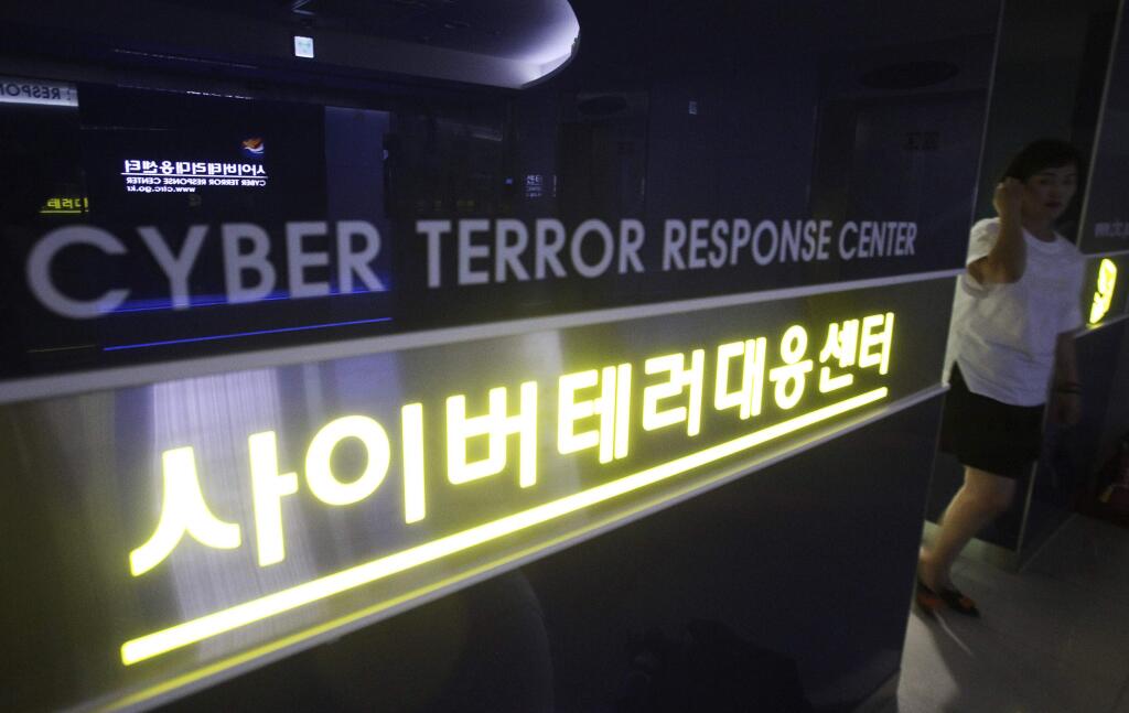 FILE - In this July 16, 2013 file photo, a woman walks by a sign at Cyber Terror Response Center of National Police Agency in Seoul, South Korea. Most North Koreans have never even seen the Internet. But the country Washington suspects is behind a devastating hack on Sony Pictures Entertainment has managed to orchestrate a string of crippling cyber infiltrations of South Korean computer systems in recent years, officials in Seoul believe, despite North Korea protesting innocence. (AP Photo/Ahn Young-joon, File)