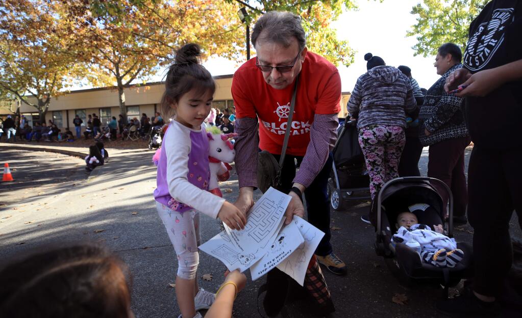 Francois Piccin lost his home during the Tubbs fire, has also volunteered his time helping those in Paradise and Camp fire victims and is now volunteering at the Healdsburg Kincade fire recovery center, Tuesday Nov. 5, 2019. Piccin gives out crayons and coloring pages to Jessica Weisheitinger's two children Cali and Tori Swan.(Kent Porter / The Press Democrat) 2019