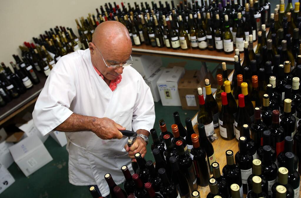 Sal Rizzo pulls corks from entries in the Harvest Fair wine competition, at the Sonoma County Fairgrounds, in Santa Rosa on Tuesday, September 16, 2014. (Christopher Chung/ The Press Democrat)