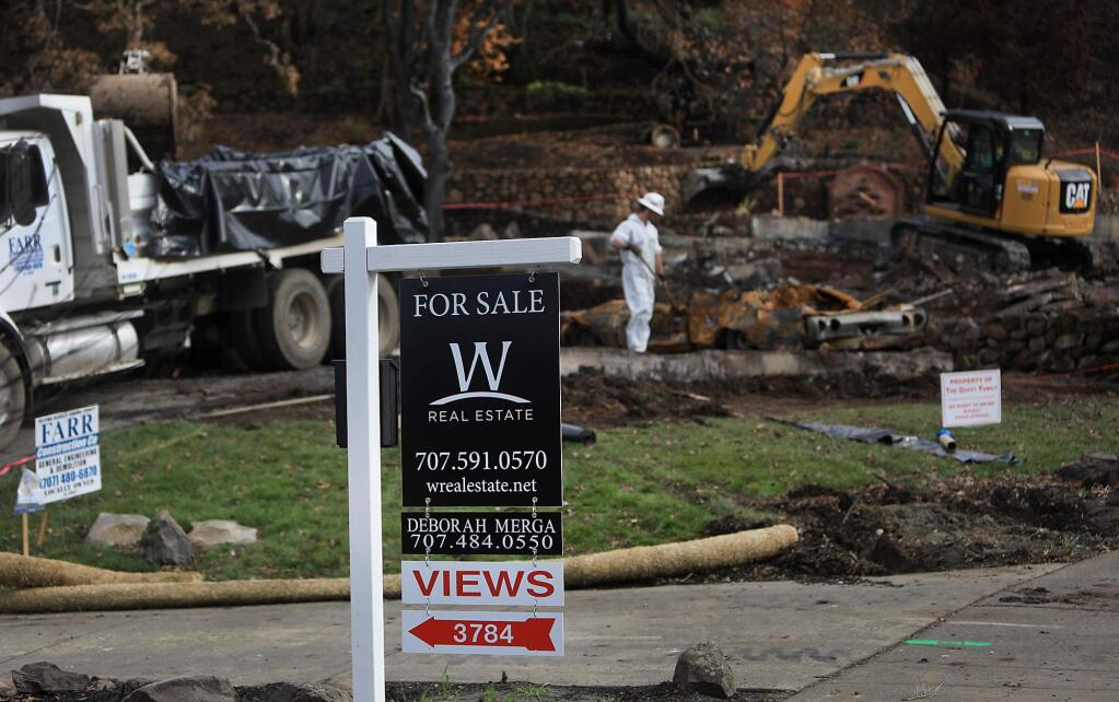Even as lots are being cleared with homeowners planning to rebuild, background, more and more for sale signs are appearing on their neighbors Fountaingrove homes, here on Cross Creek Circle, Tuesday Dec. 9, 2018 in Santa Rosa. (Kent Porter / The Press Democrat) 2018