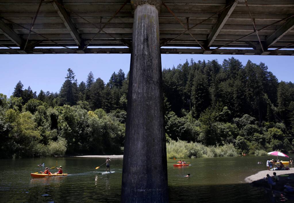 People paddle and swim in the Russian River near the Bohemian Hwy bridge in Monte Rio, on Monday, June 27, 2016. (BETH SCHLANKER/ The Press Democrat)