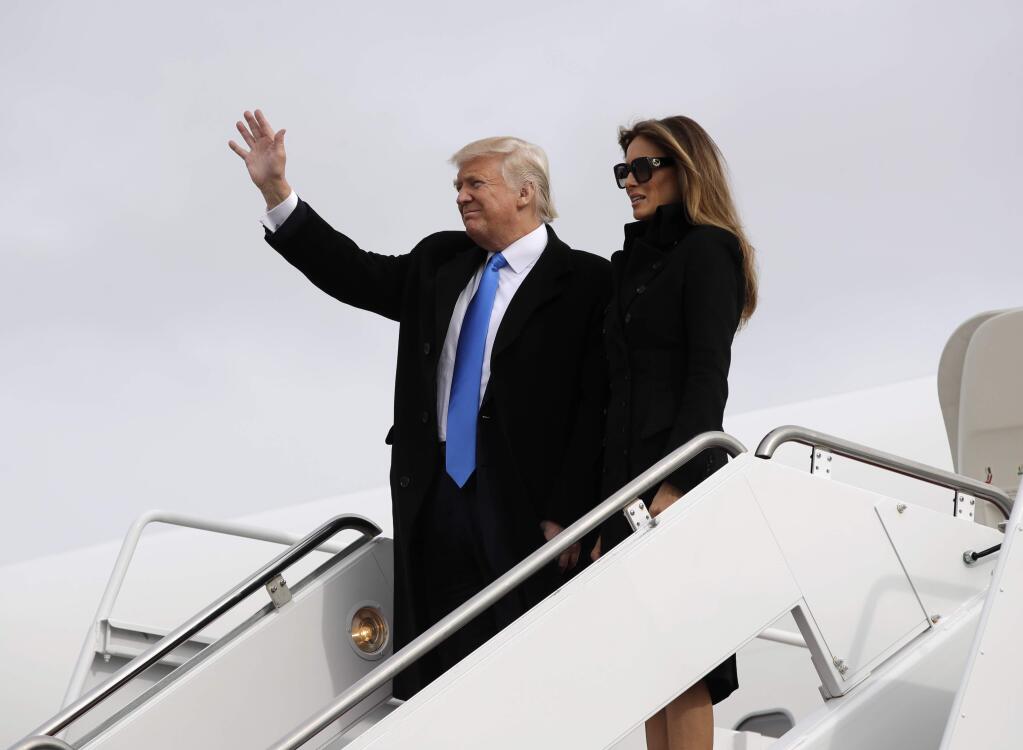 President-elect Donald Trump, accompanied by his wife Melania, waves as they arrive Thursday at Andrews Air Force Base in advance of Friday's inauguration. (EVAN VUCCI / Associated Press)