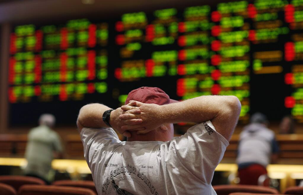 A man watches a baseball game in the sports book at the South Point hotel-casino, Monday, May 14, 2018, in Las Vegas. The Supreme Court on Monday gave its go-ahead for states to allow gambling on sports across the nation, striking down a federal law that barred betting on football, basketball, baseball and other sports in most states. (AP Photo/John Locher)