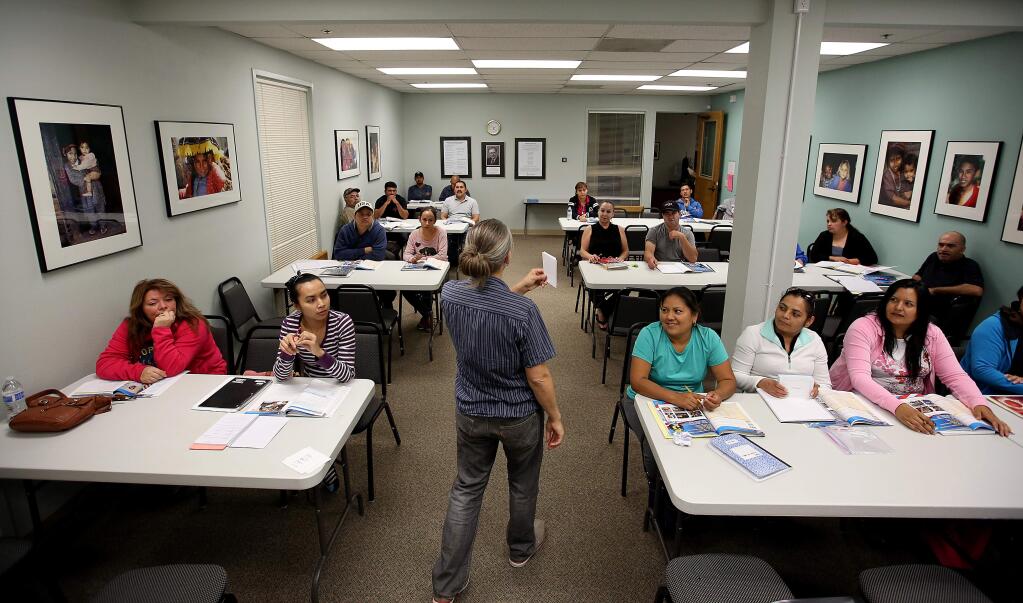 Bridget Hayes quizzes the students taking the citizenship class at Catholic Charities, Thursday, October 9, 2014. (Crista Jeremiason / The Press Democrat)