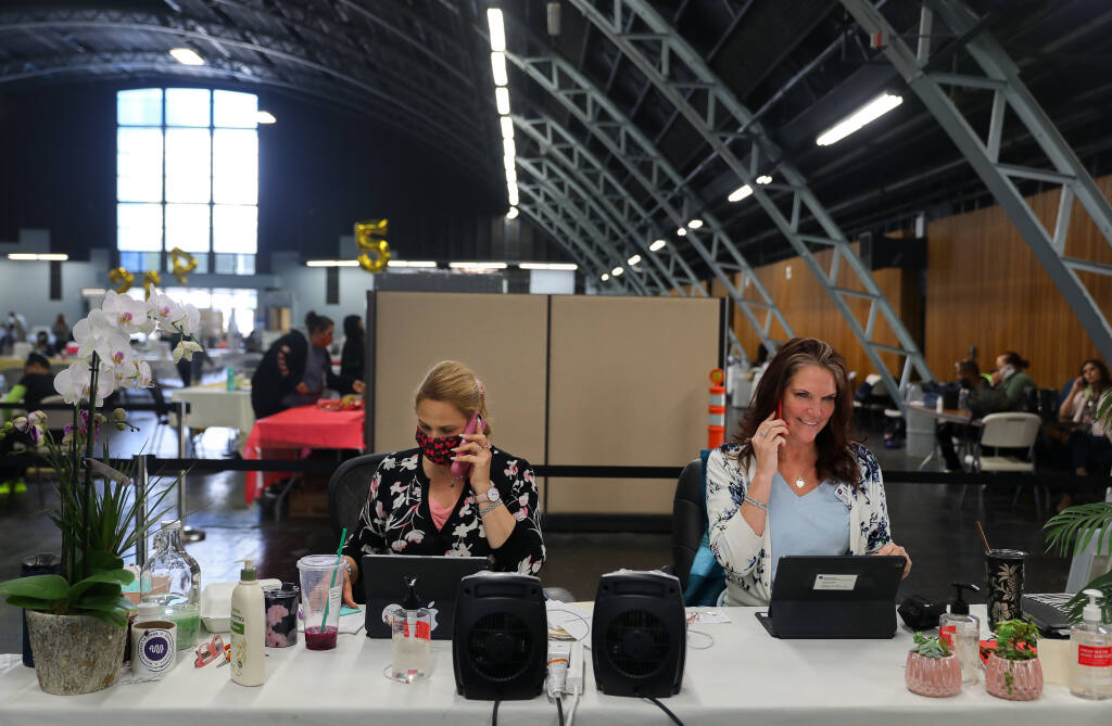 Sonoma County Medical Association executive director Wendy Young, right, and her assistant Rachel Pandolfi make phone calls in an effort to locate individuals that want to get vaccinated to use leftover vaccine near the end of the day at the Sonoma County Medical Association vaccination clinic, at the Sonoma County Fairgrounds, in Santa Rosa on Friday, April 23, 2021.  (Christopher Chung/ The Press Democrat)