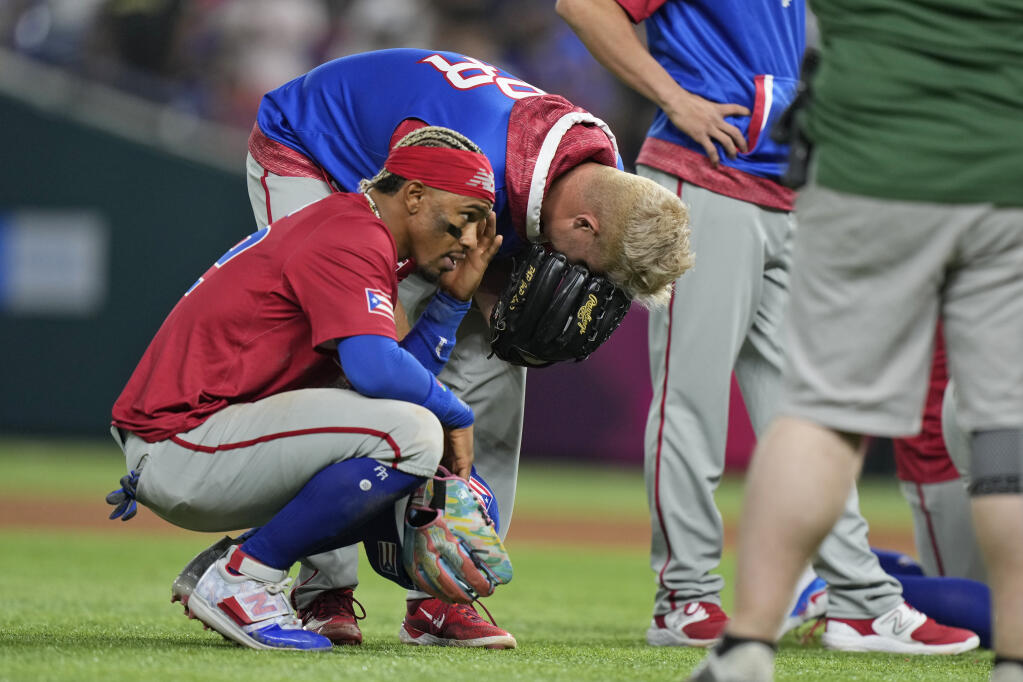 Puerto Rico players react after pitcher Edwin Díaz appeared to be injured during postgame celebration after Puerto Rico beat the Dominican Republic 5-2 during a World Baseball Classic game, Wednesday, March 15, 2023, in Miami. (Wilfredo Lee / ASSOCIATED PRESS)