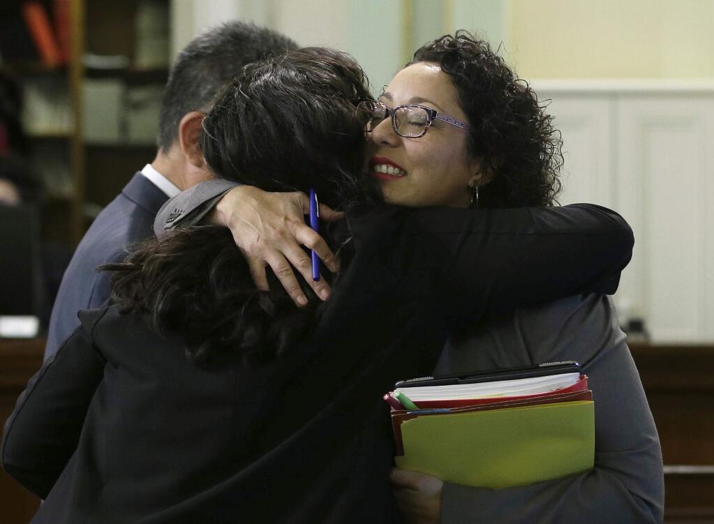 Assemblywoman Cristina Garcia, D-Bell Gardens, right, is hugged by Assemblywoman Wendy Carrillo, D-Los Angeles, on her first day back in the Assembly since an investigation into sexual misconduct charges, Friday, May 25, 2018, Sacramento, Calif. Garcia took a three-month leave of absence after a groping allegation and other claims of inappropriate behavior surfaced. Outside investigators cleared her of the groping claim but found she used vulgar language in violation of the Assembly's sexual harassment policy. (AP Photo/Rich Pedroncelli)