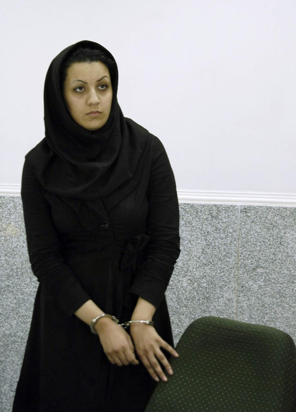 In this picture taken on July 8, 2007, Iranian Reyhaneh Jabbari stands handcuffed in a police office in Tehran, Iran. Jabbari was hanged on Saturday, Oct. 25, 2014, who was convicted of murdering a man she said was trying to rape her, the official IRNA news agency reported. (AP Photo/Golara Sajjadian)