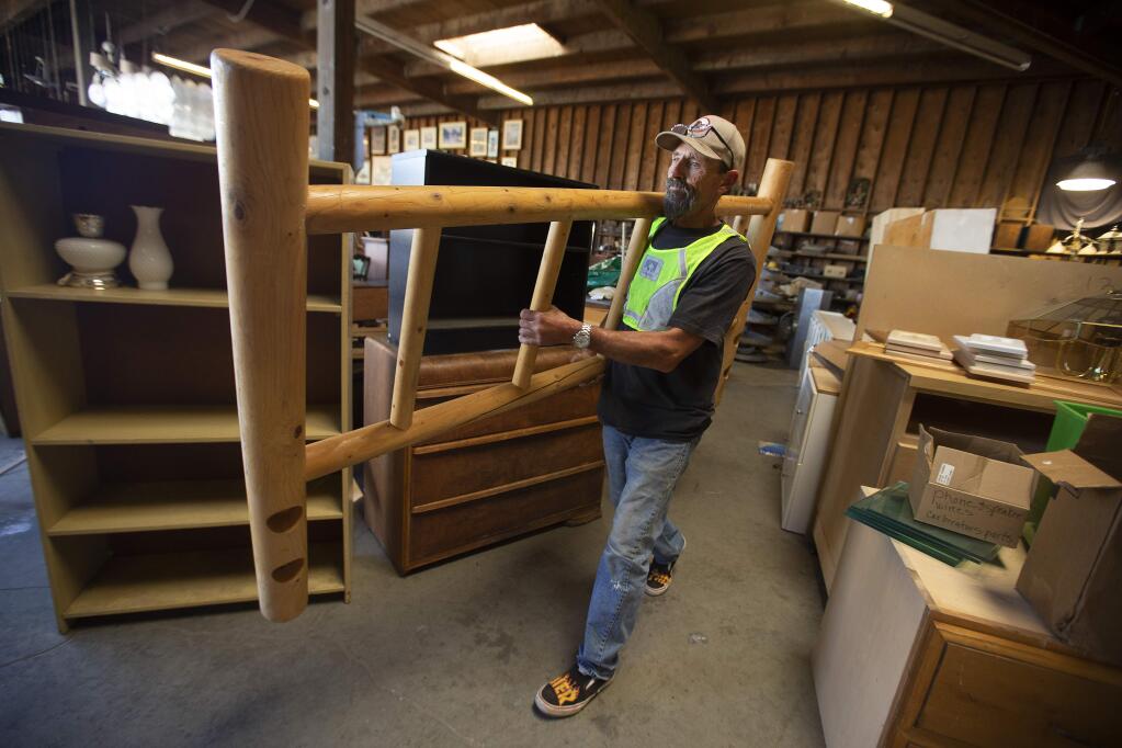 Ronnie Giannini helps a customer load a bed frame at Recycletown in the Sonoma County Central Disposal Site on Meecham Rd. The drop-off area for reuse items is being forced to downsize to make way for a green waste center. (photo by John Burgess/The Press Democrat)