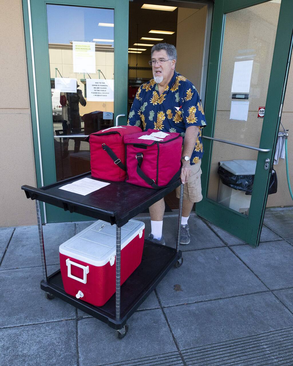 Meals on Wheels driver Jim McLaughlin loads his car with food for delivery to seniors at the Council on Aging kitchen in Santa Rosa on Wednesday, April 1, 2020. (John Burgess/The Press Democrat)