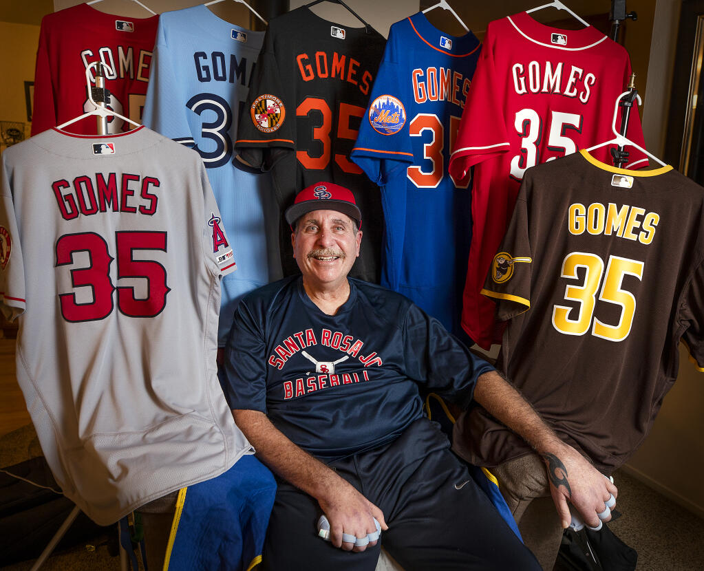 Sam Gomes with just some jerseys he received from major league jerseys teams after he was recently diagnosed with ALS, also known as Lou Gerhrig's disease. Sam played catcher for SRJC in the 1980s and was an assistant coach until he was wheelchair bound by the disease. Photographed at his Santa Rosa home on Friday, Nov. 5, 2021.   (Photo by John Burgess/The Press Democrat)