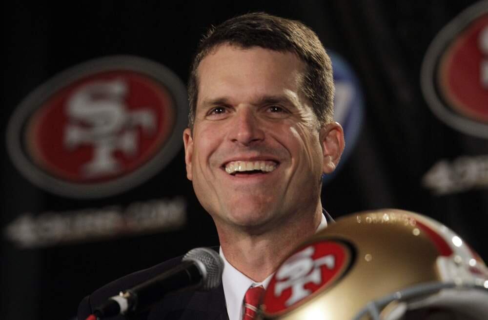 Jim Harbaugh smiles during a news conference Friday, Jan. 7, 2011, in San Francisco. Harbaugh currently coaches the Michigan Wolverines, where he played college football and was a Heisman Trophy finalist. (AP Photo/Ben Margot)