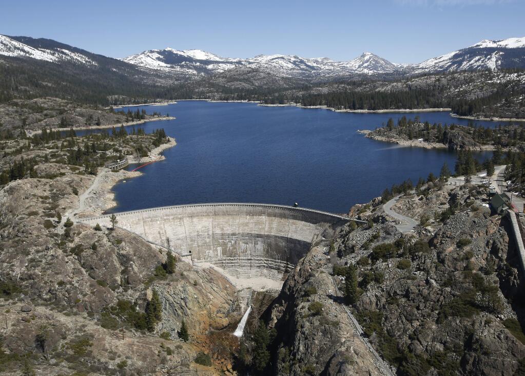 Snow covering the Sierra Nevada is seen in the background of the PG&E hydroelectric dam at Spaulding Lake in Nevada County. (RICH PEDRONCELLI / Associated Press)