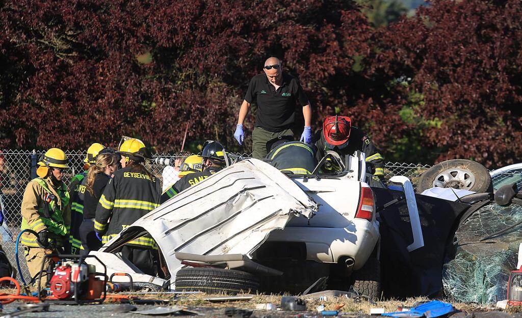 Rescue personnel prepare to pull a victim from a crash on Highway 101 in Geyserville on Friday, Aug. 14, 2015. The JAWS of life had to be used to peel back the roof of the SUV. (KENT PORTER/ PD)