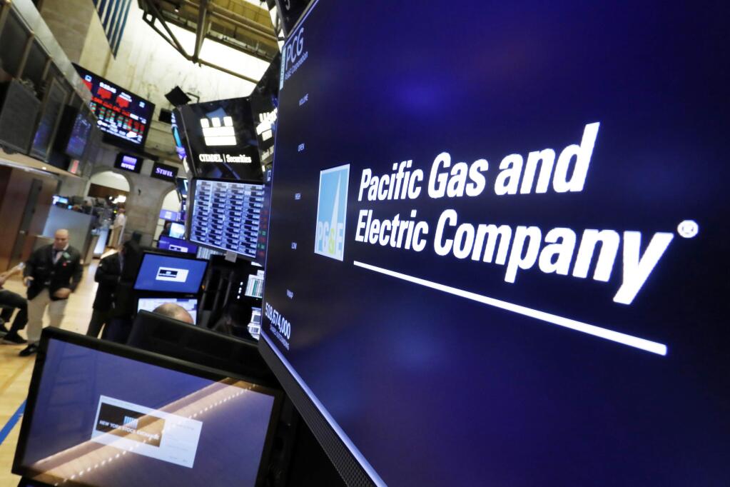 FILE - This Jan. 14, 2019, file photo shows the logo for Pacific Gas & Electric Co. above a trading post on the floor of the New York Stock Exchange. (AP Photo/Richard Drew, File)