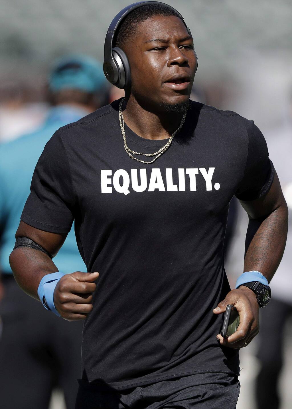 Oakland Raiders cornerback T.J. Carrie wears an Equality shirt while warming up before an NFL football game against the Baltimore Ravens in Oakland, Calif., Sunday, Oct. 8, 2017. (AP Photo/Marcio Jose Sanchez)