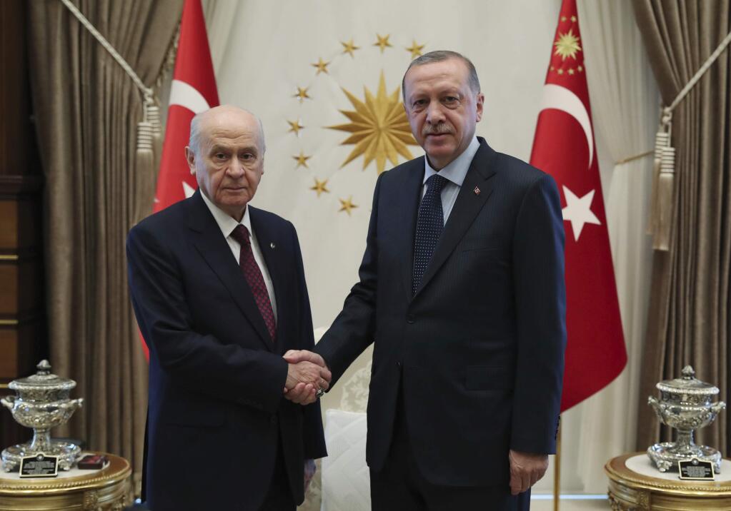 Turkey's President Recep Tayyip Erdogan, right, and Devlet Bahceli, leader of opposition Nationalist Movement Party and Erdogan's main ally in June 24 presidential election, shake hands before a meeting in Ankara, Turkey, Tuesday, July 31, 2018. Erdogan was elected under a new governing system that gives him sweeping executive powers.(Presidency Press Service via AP, Pool)
