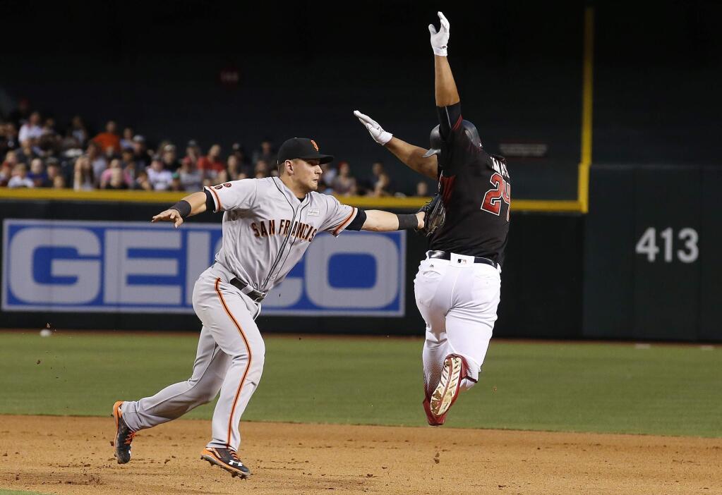 San Francisco Giants' Joe Panik, left, tags out Arizona Diamondbacks' Yasmany Tomas, right, as Tomas tries to get to second base during the seventh inning of a baseball game Saturday, May 14, 2016, in Phoenix. (AP Photo/Ross D. Franklin)