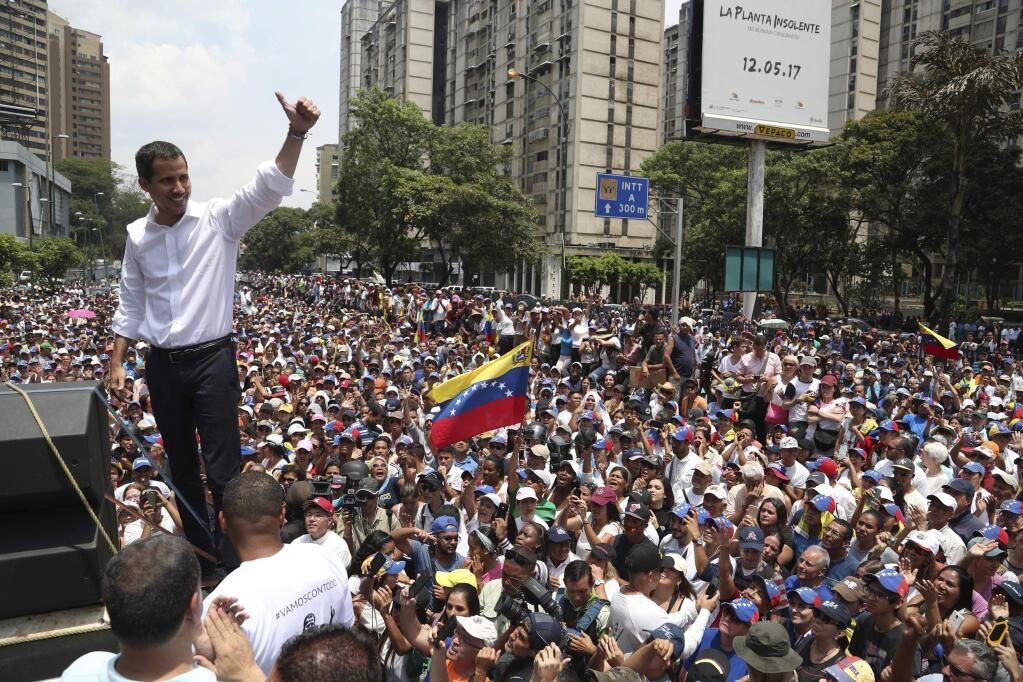Opposition leader Juan Guaidó flashes a thumbs up at supporters during a rally in Caracas, Venezuela, Wednesday, May 1, 2019. Guaidó called for Venezuelans to fill streets around the country Wednesday to demand President Nicolas Maduro's ouster. Maduro is also calling for his supporters to rally. (AP Photo/Martin Mejia)