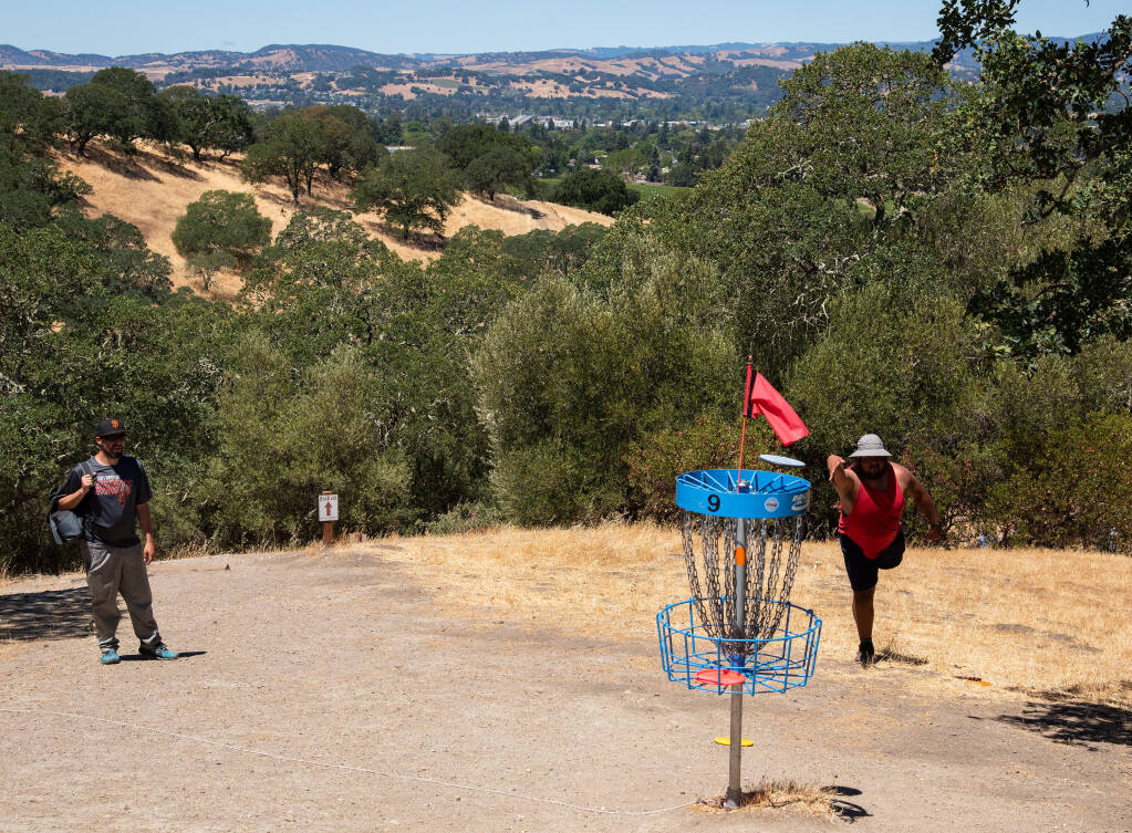 Mito Tellez, right, of Napa putts at scenic 9th Hole of the 18-hole disc golf course at Skyline Wilderness Park while Billy Murphy looks on, in Napa, Calif. on Saturday, June 12, 2021. (Alvin A.H. Jornada for The Press Democrat)