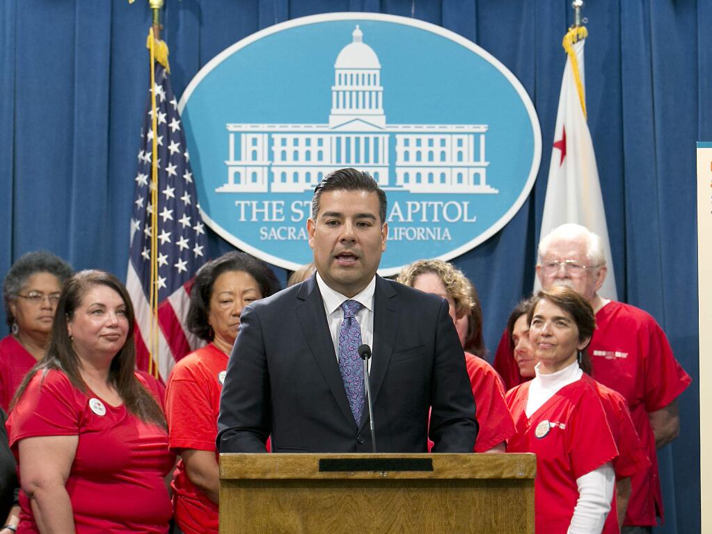 State Sen. Ricardo Lara, D-Bell Gardens, accompanied by members of the California Nurses Association, discusses his single-payer health care bill at a Capitol news conference, Wednesday, May 31, 2017, in Sacramento, Calif. (AP Photo/Rich Pedroncelli)