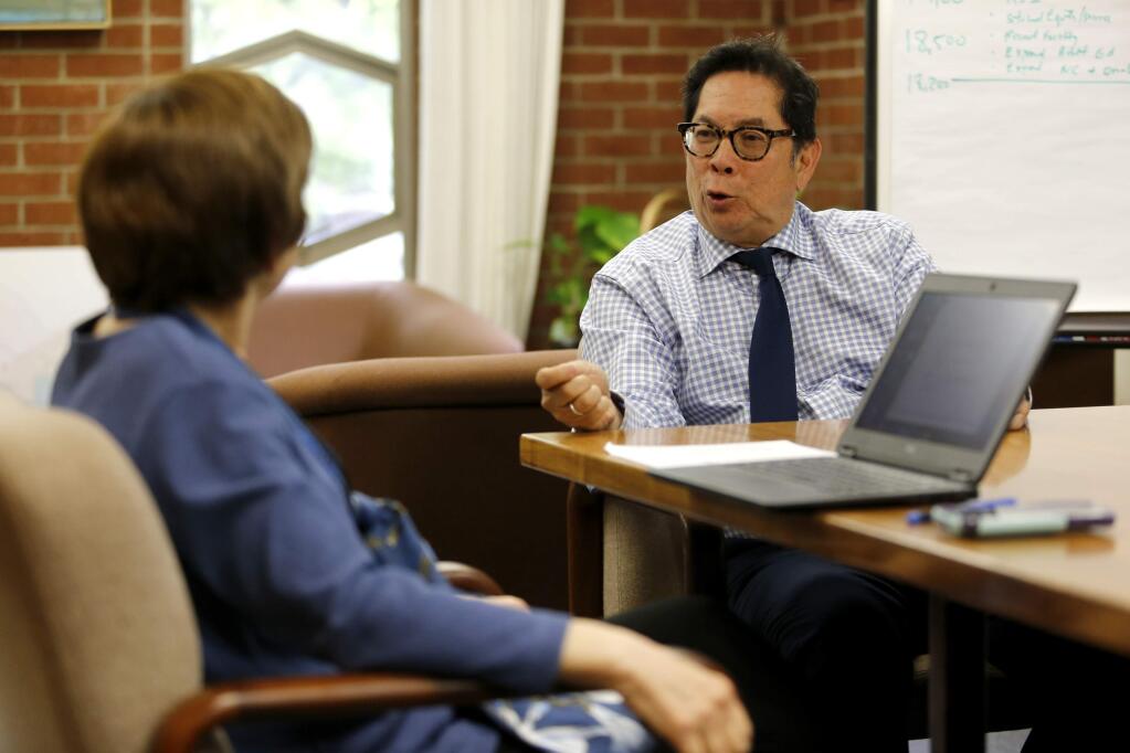 Santa Rosa Junior College Superintendent/President Dr. Frank Chong, talks with Ellen Maremont Silver, SRJC Director of Communications and Marketing, during a weekly meeting at his office on the SRJC campus in Santa Rosa, on Thursday, May 5, 2016. (BETH SCHLANKER/ The Press Democrat)