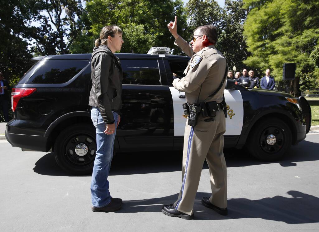 California Highway Patrol Officer Gary Martens, right, has CHP Sgt. Jaimi Kenyon, follow his finger during a demonstration of how drivers, suspected of impaired driving, are currently tested, Wednesday, May 10, 2017, in Sacramento, Calif. Three of California's largest counties are testing a device that can detect the presence of drugs in saliva within five minutes. Some officers and lawmakers want the devices used statewide after voters passed Proposition 64 in November, legalizing the recreational use of marijuana. (AP Photo/Rich Pedroncelli)
